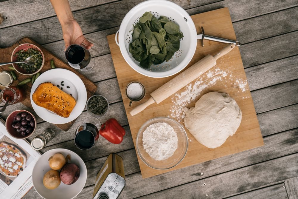 Ingredientes medidos y utensilios de repostería casera sobre mesa de madera